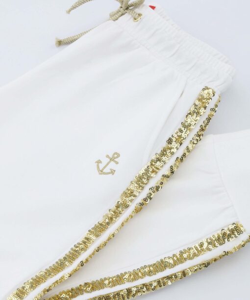 Spodnie dresowe w marynistycznym stylu białe ze złotym brokatem.